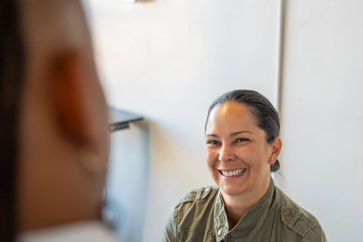 A smiling patient talking with Dr. Jamal Früster during a visit at Alma Sana Chiropractic Studio