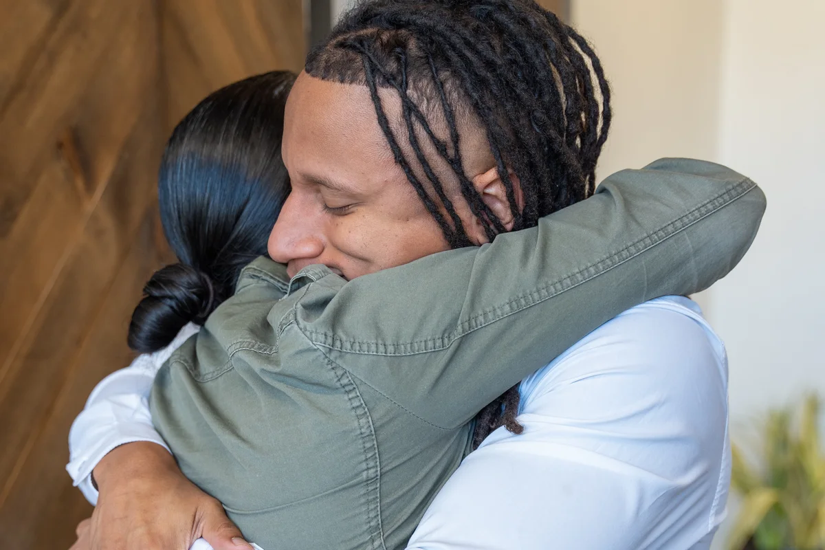 Dr. Jamal Früster greeting a patient with a hug in the studio
